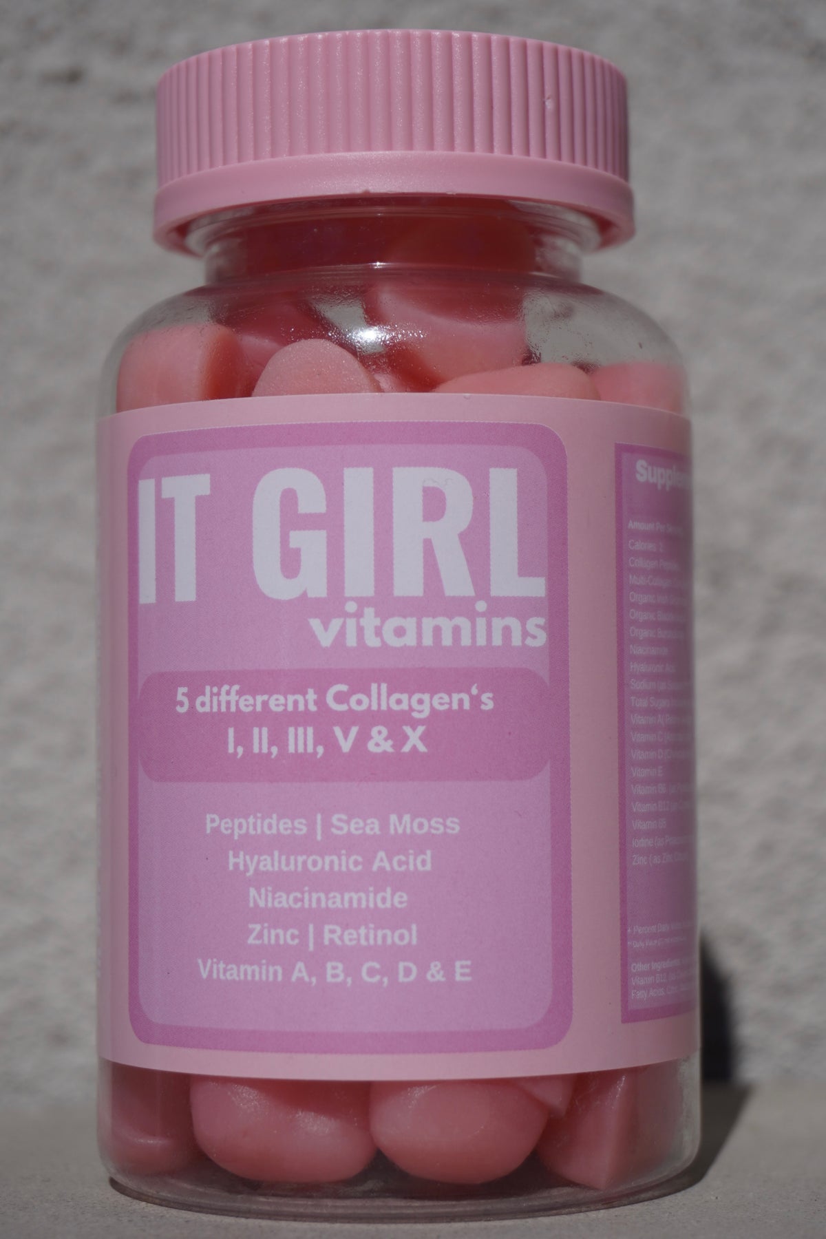 Pink It Girl Vitamins bottle filled with pink gummies.