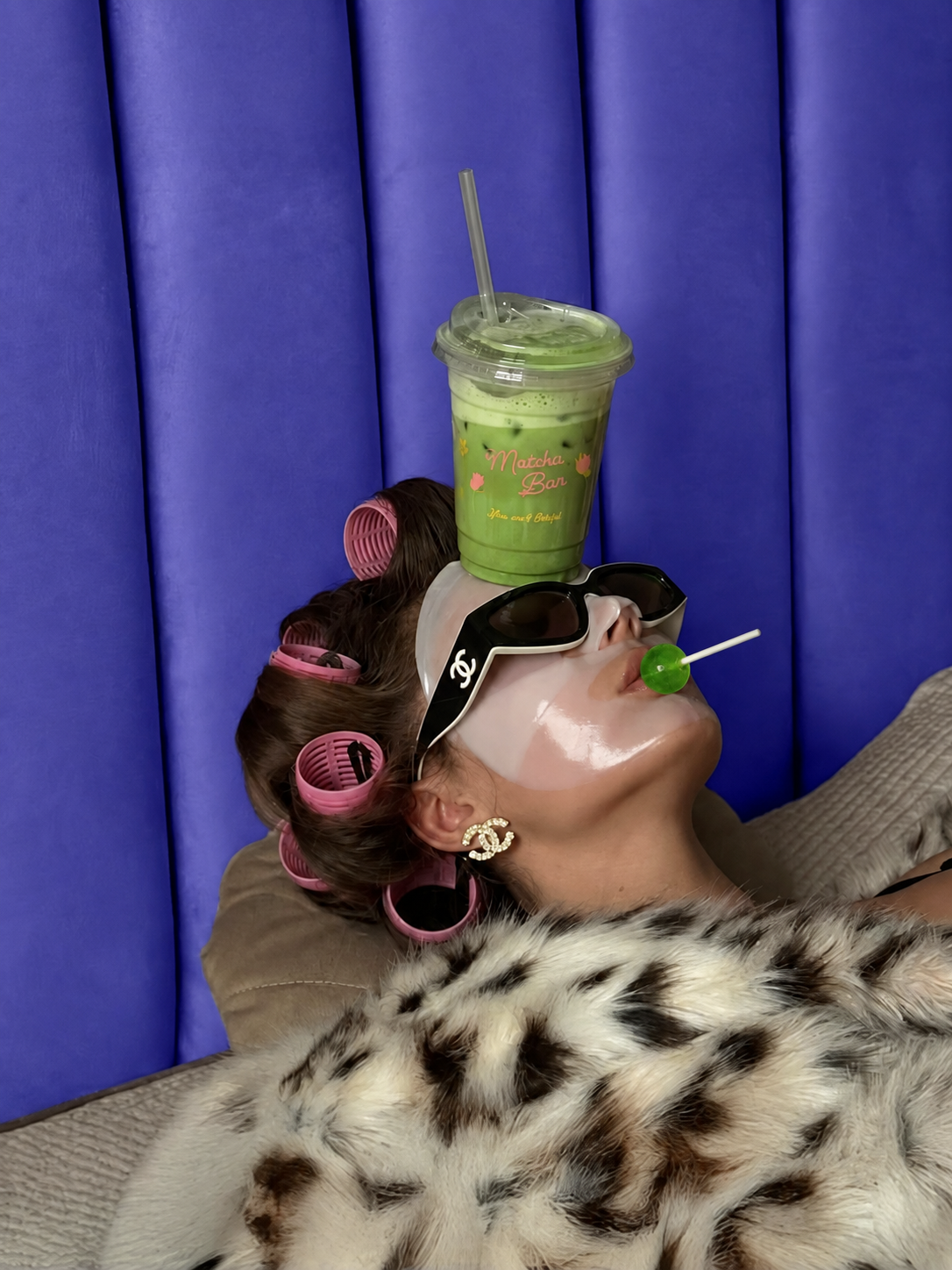 A woman holding a pink It Girl peptide beauty lollipop and the Peptide Lollipops pouch